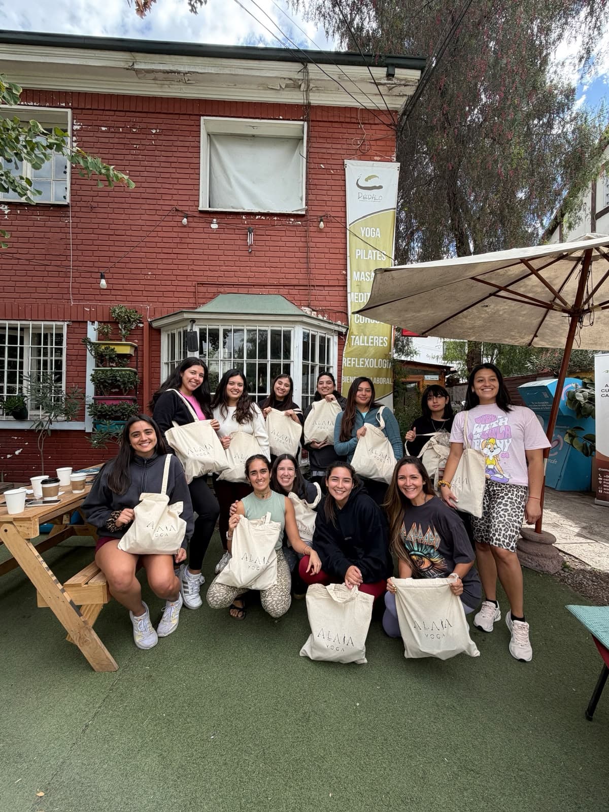 Grupo de alumnas afuera del estudio con bolsas de tela, después de un evento